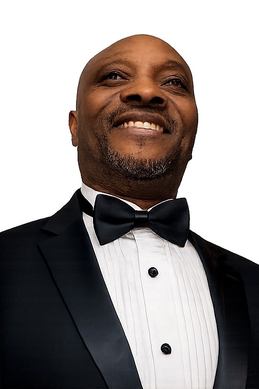 John Saint Vil smiling in a formal tuxedo